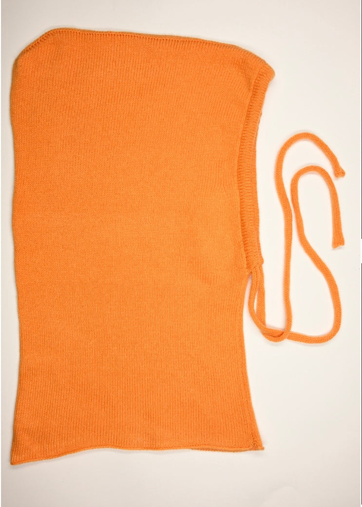 A flat lay of our cashmere knitted balaclava hood in clementine with a white background