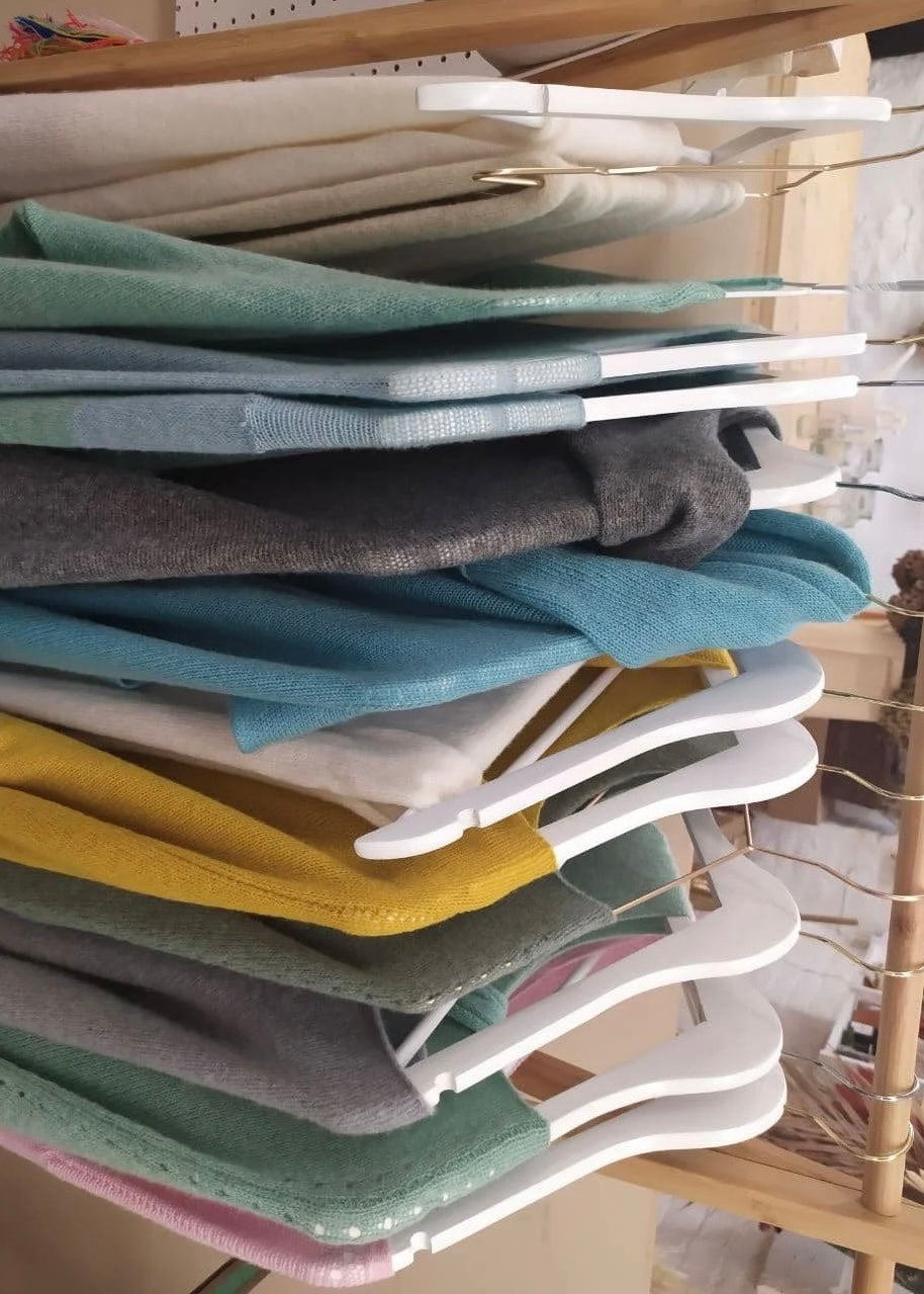 Stack of folded clothes on a rack with a wooden background