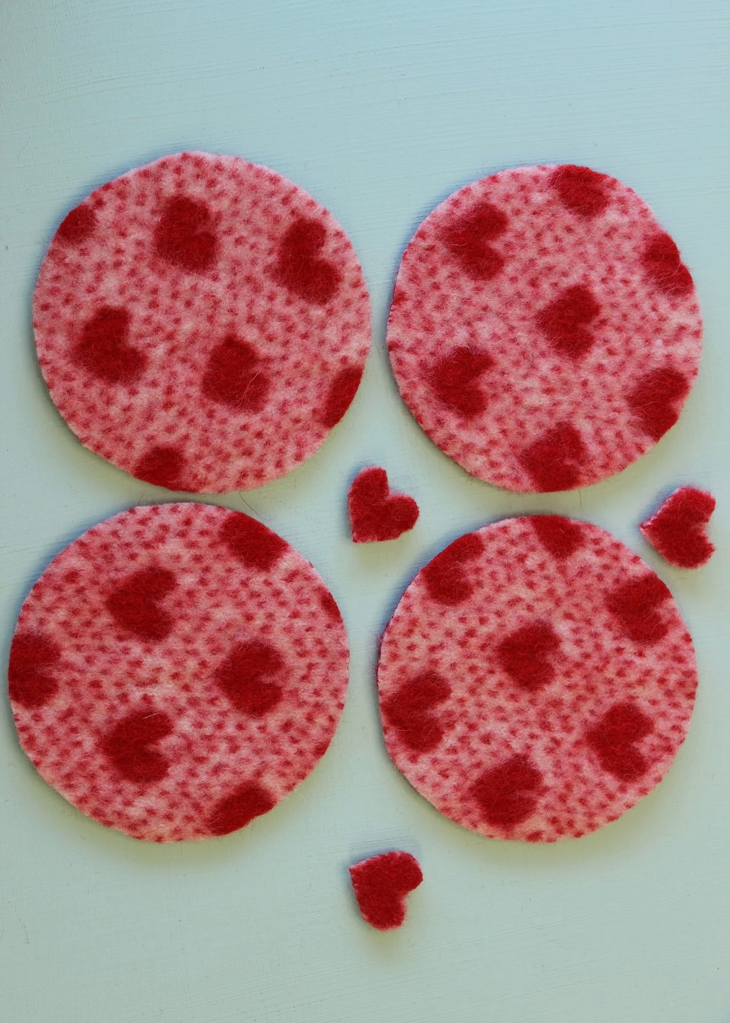Four red polka dot coasters on a white background