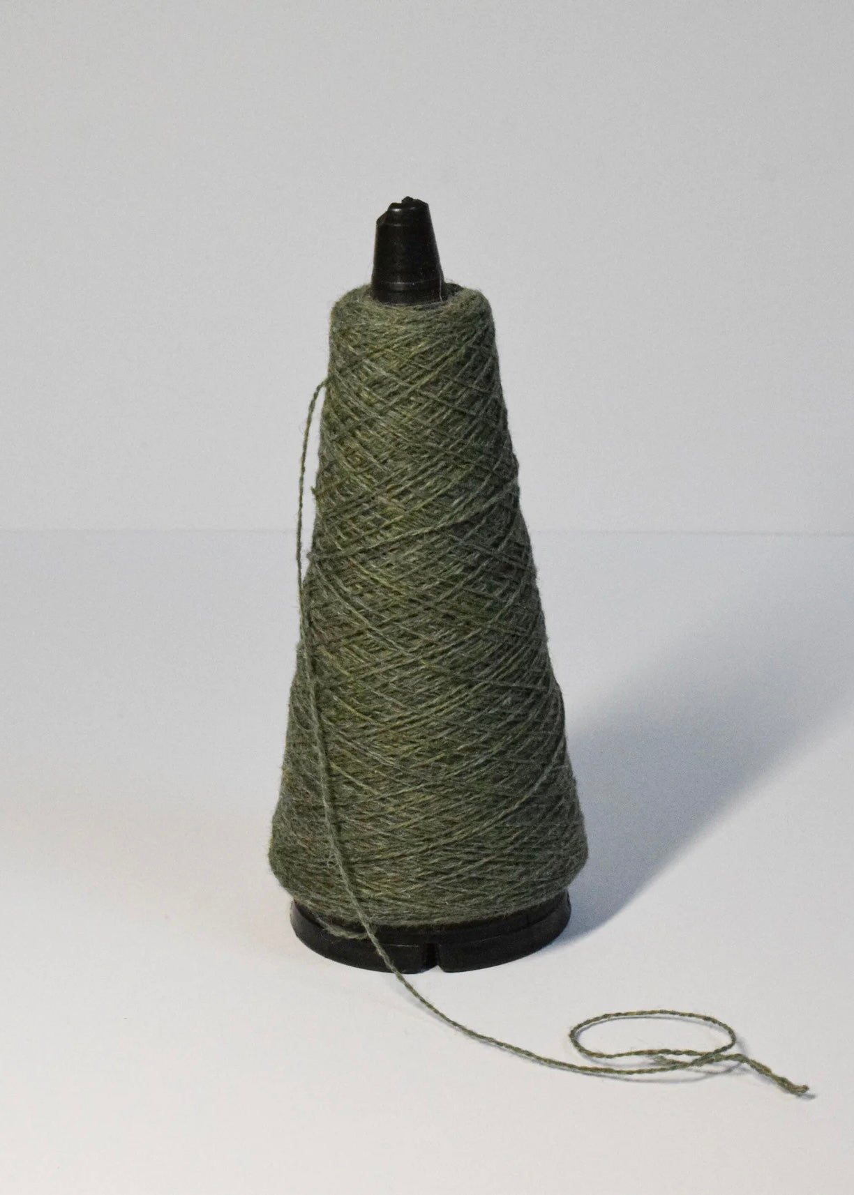 A green yarn roll with a white background