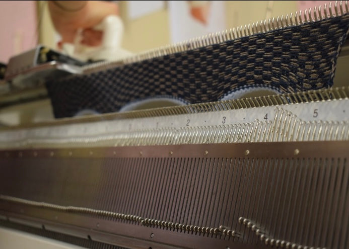 Textile machine with a needle bar and fabric being processed