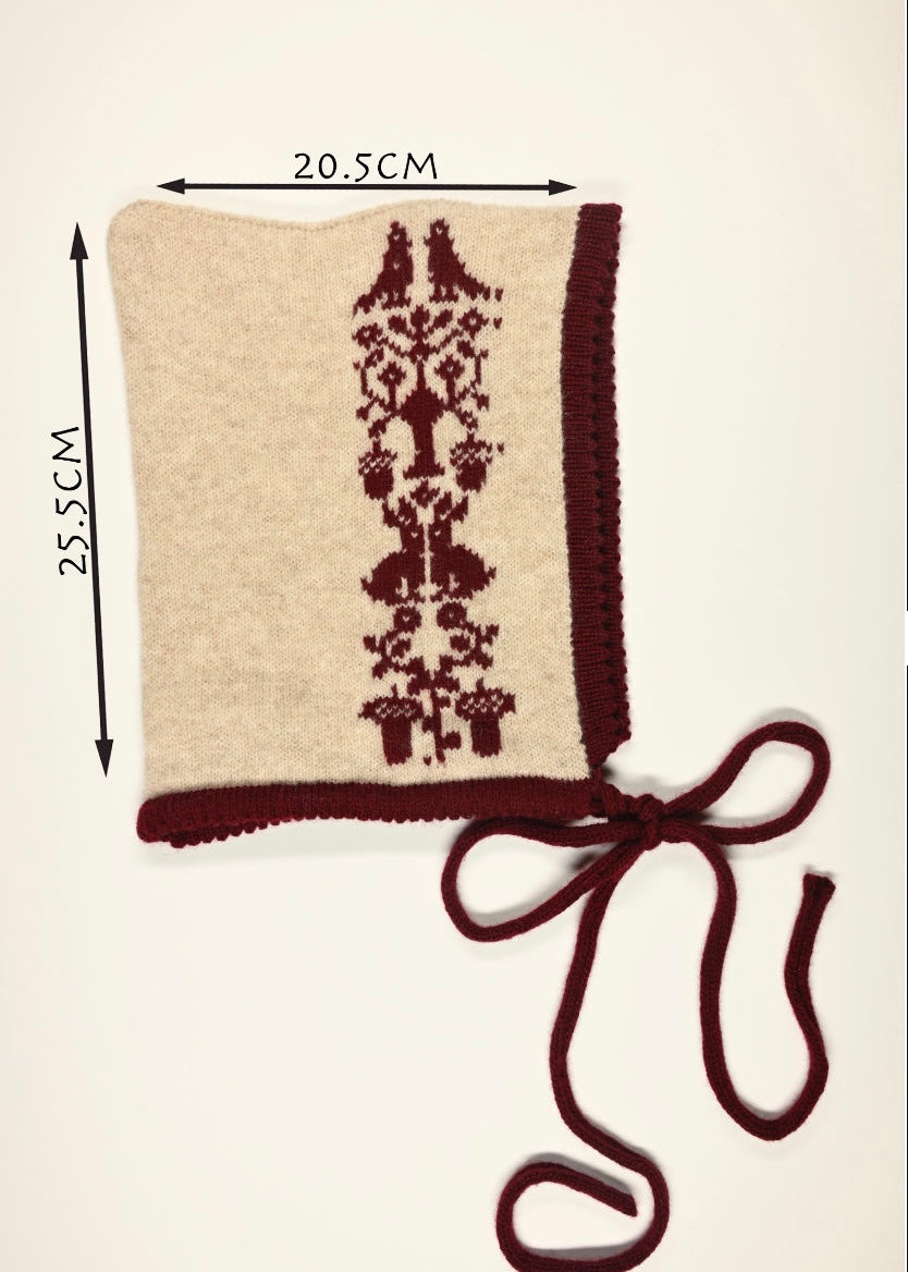 Beige bonnet with burgundy floral pattern and matching ribbon, shown with measurements (20.5cm wide by 25.5cm long) on a white background.