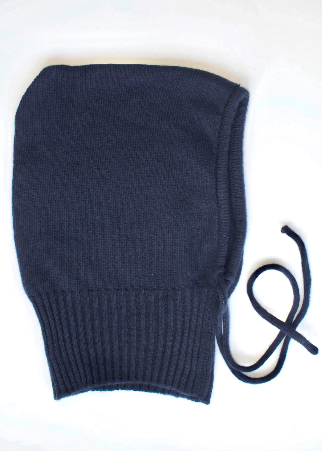 A flay lay of our cashmere knitted balaclava hood in navy with a white background 