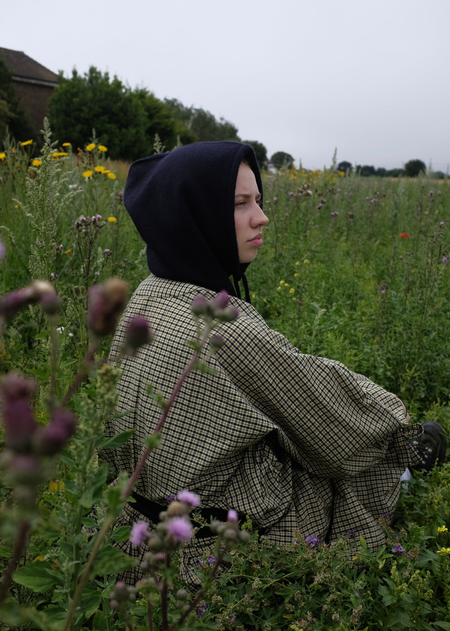 Out cashmere knitted balaclava hood in black pictured on a woman from a side view outdoors 