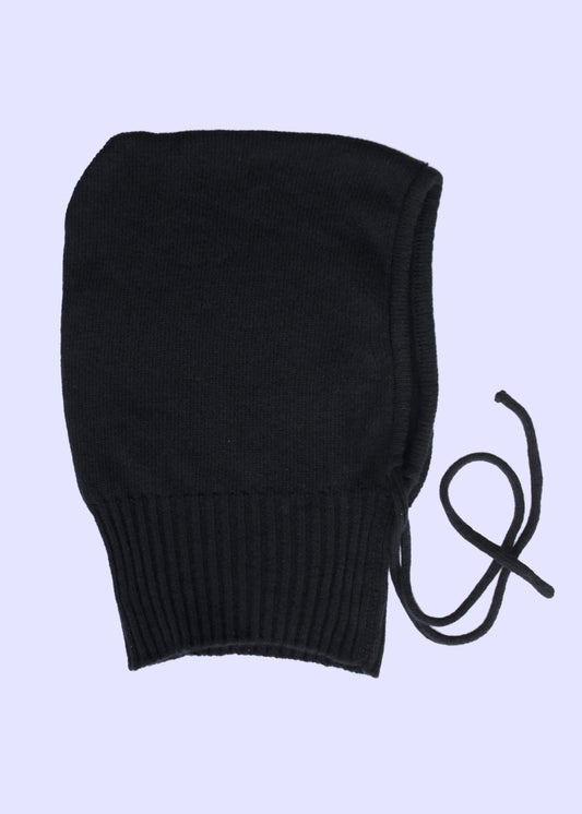 Black knit bonnet with drawstring on a light purple background