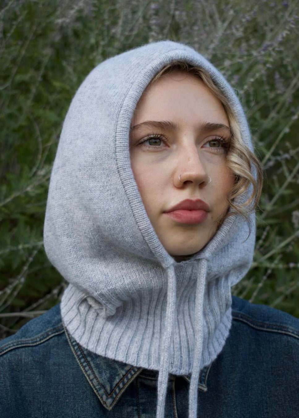 Our cashmere knitted balaclava hood in grey pictured on a woman outdoors 