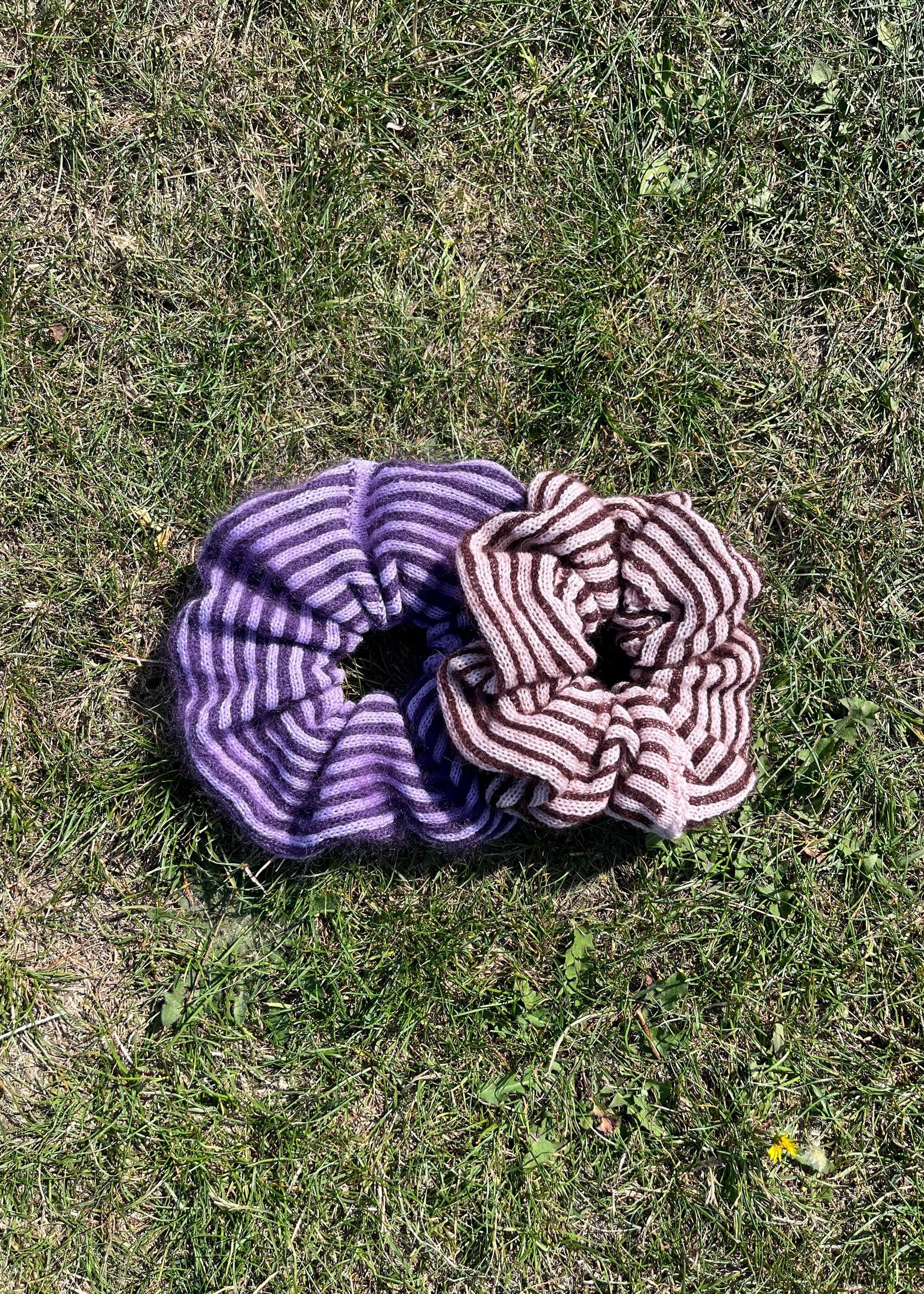 Two striped knitted scrunchies on grass