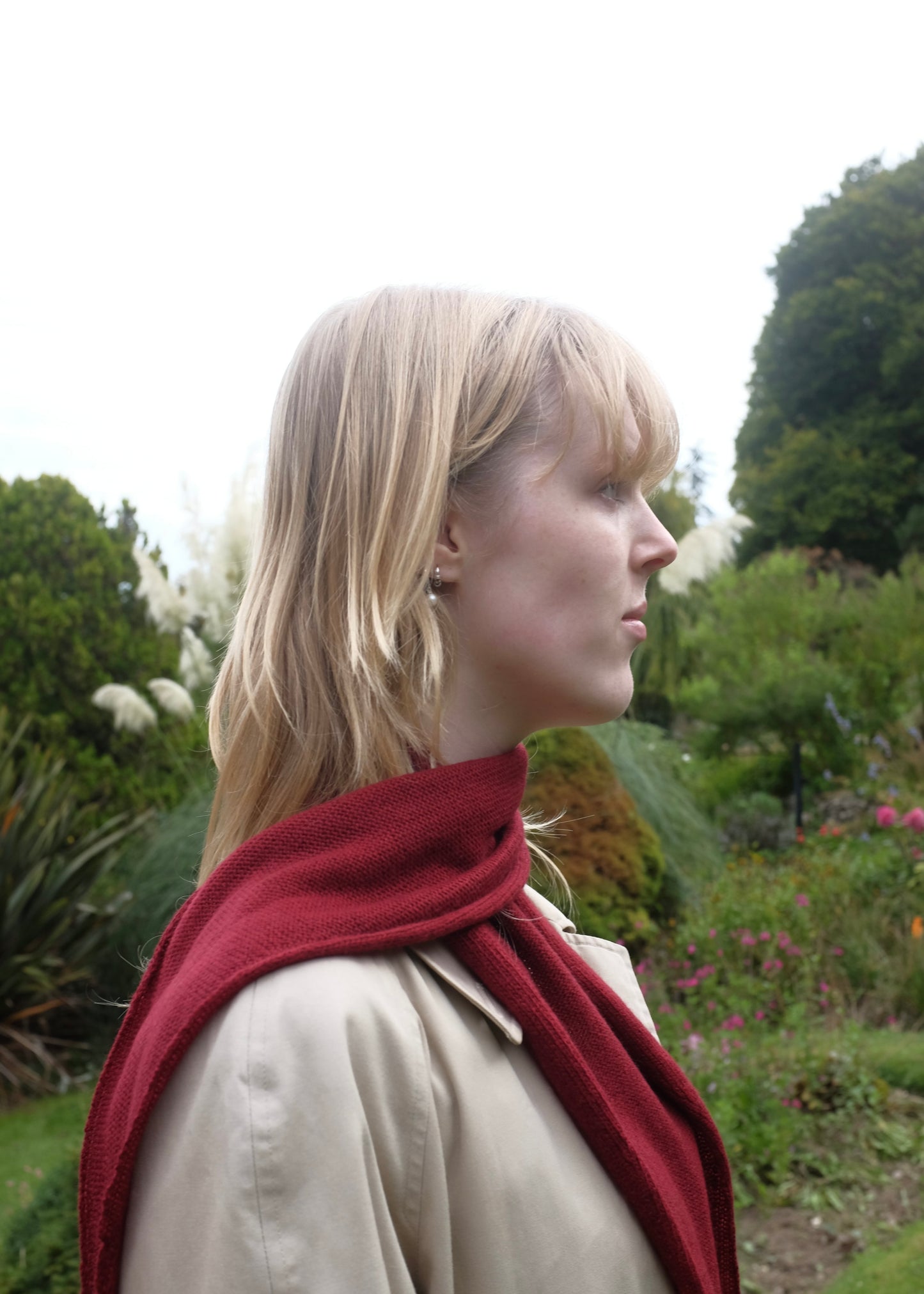 Woman wearing a red scarf in a garden setting