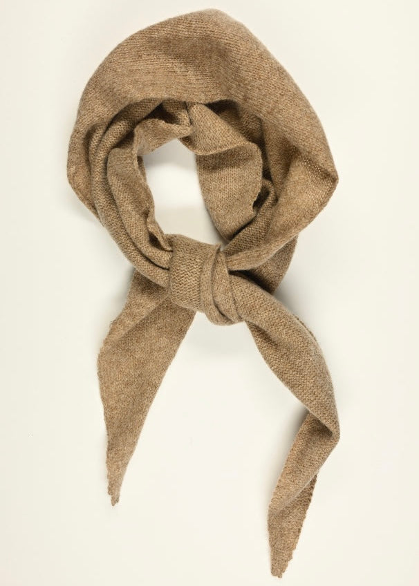 A flat lay of  beige scarf tied in a not against a white background