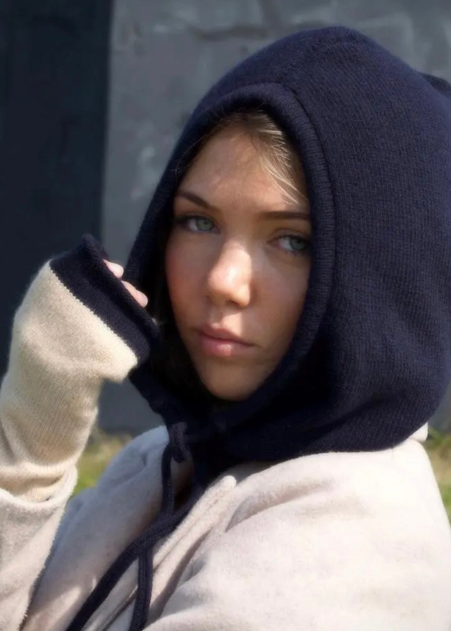 Our cashmere knitted balaclava hood in navy pictured on a woman outdoors 
