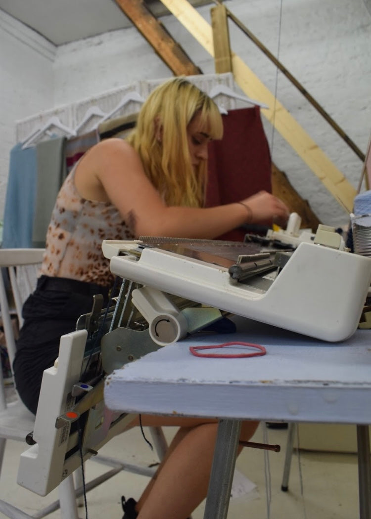 Person working at a sewing machine in a workshop setting