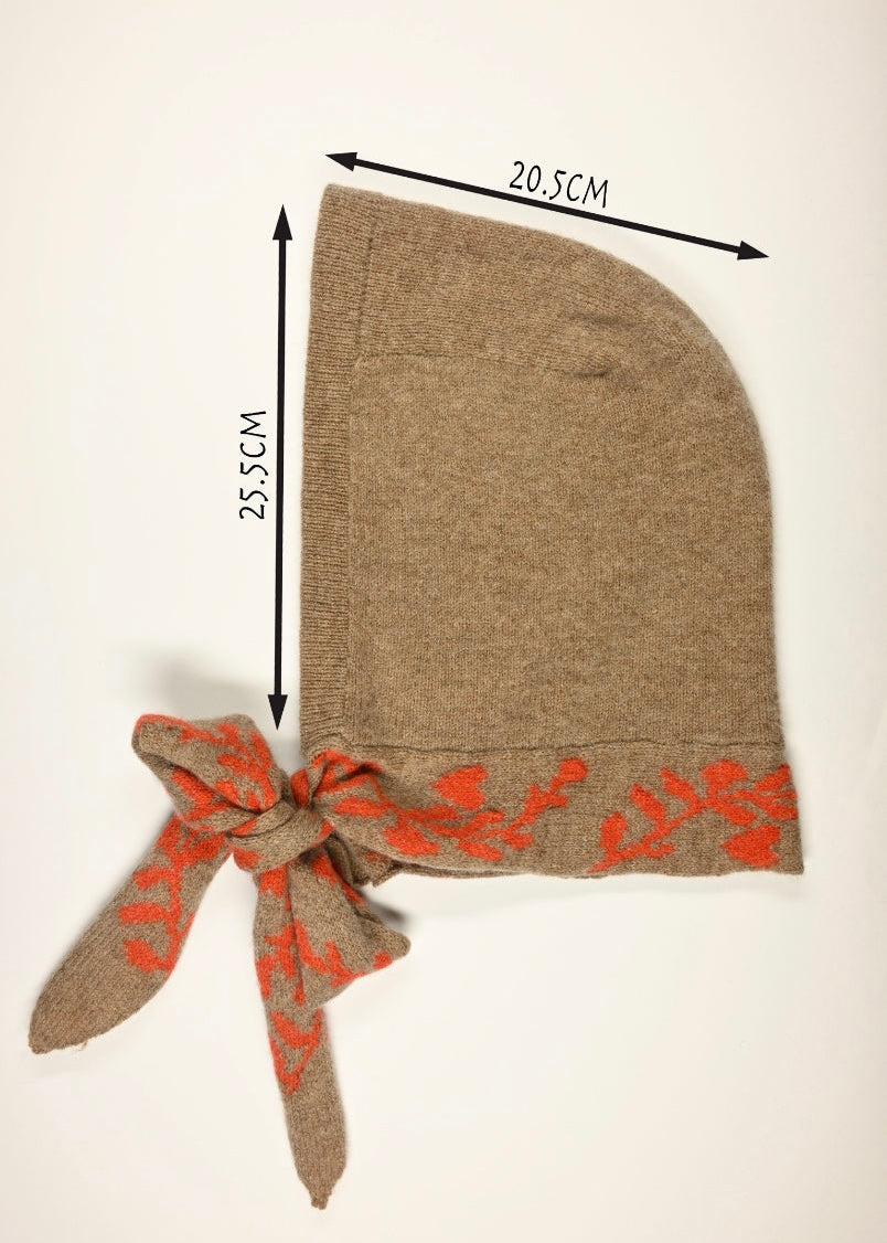 Tan lambswool knitted hooded bonnet with floral orange trim and measurements on a white background, 20.5cm wide by 25.5cm long 