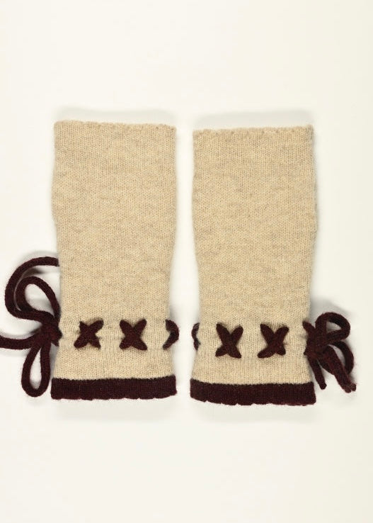 Pair of cream arm warmers with dark purple  decorative elements on a white background