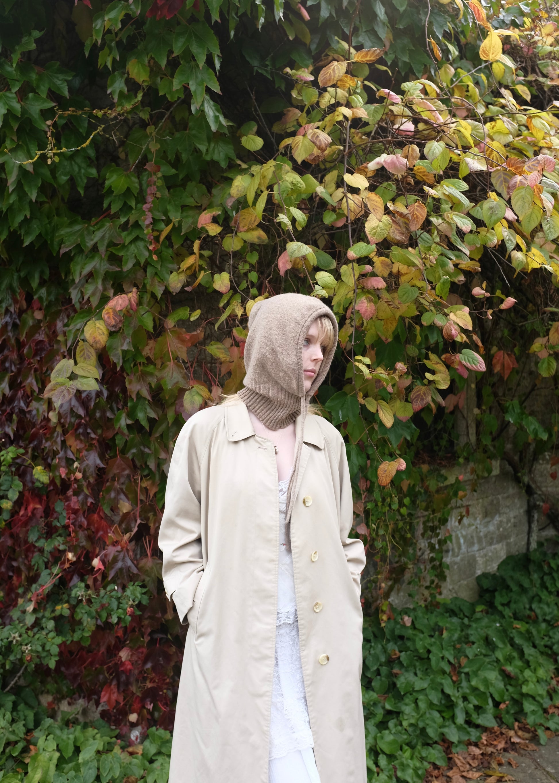 Our cashmere knitted hood balaclava in tan pictured on a woman outdoors 