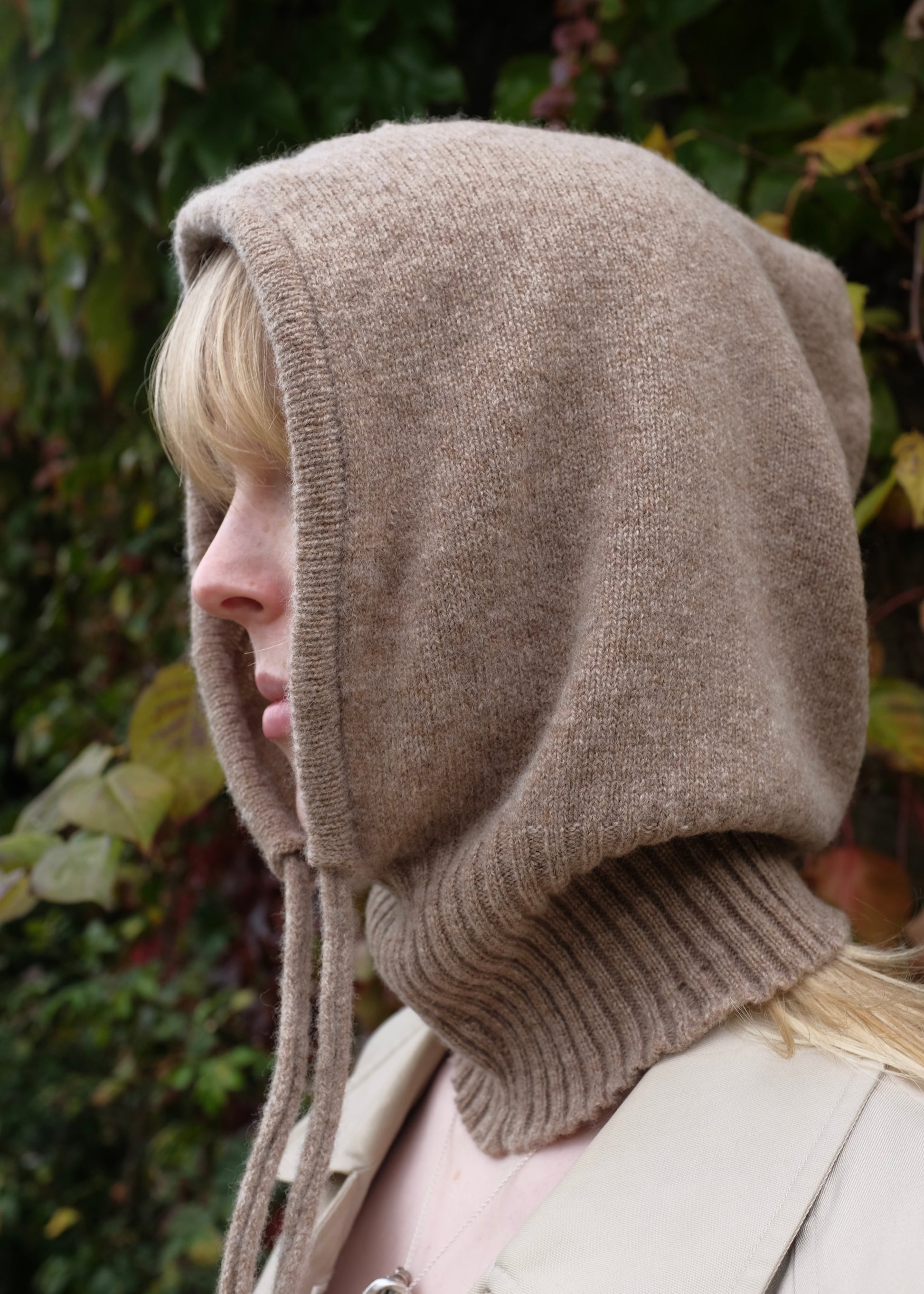 Our cashmere knitted balaclava hood in tan pictured on woman outdoors 
