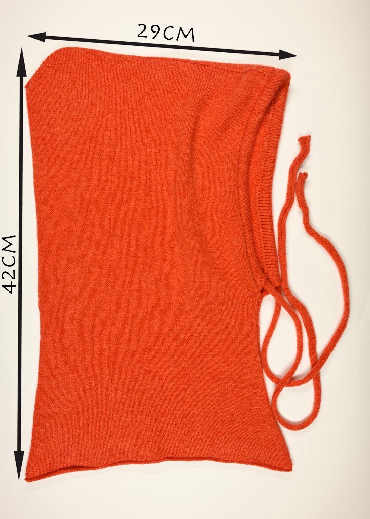 A flat lay of our cashmere knitted balaclava hood in orange on a whit3 background displaying the measurements of 42cm long by 29cm 