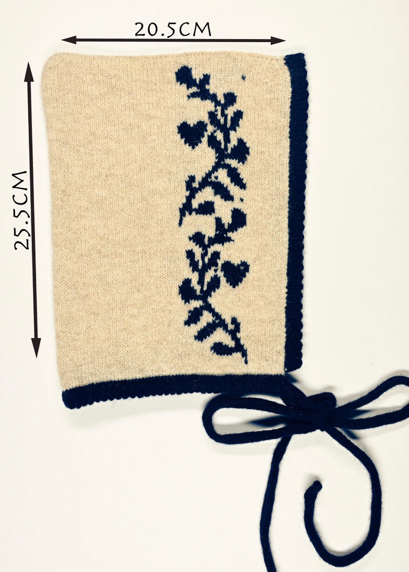 Beige fabric square with navy floral design and a bow, with measurements indicated of 20.5cm wide by 25.5cm long