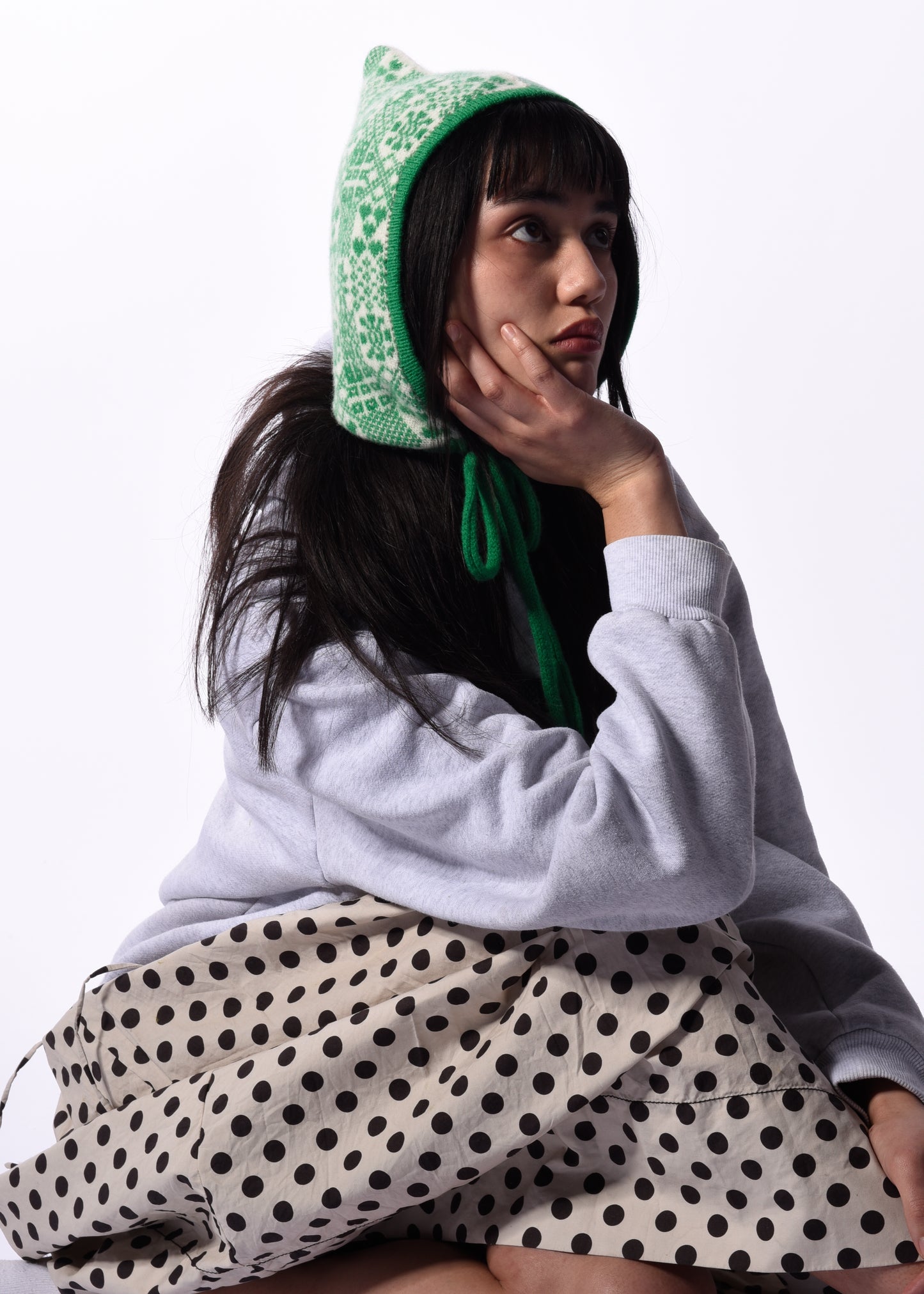 Person wearing a green bonnet with a white background