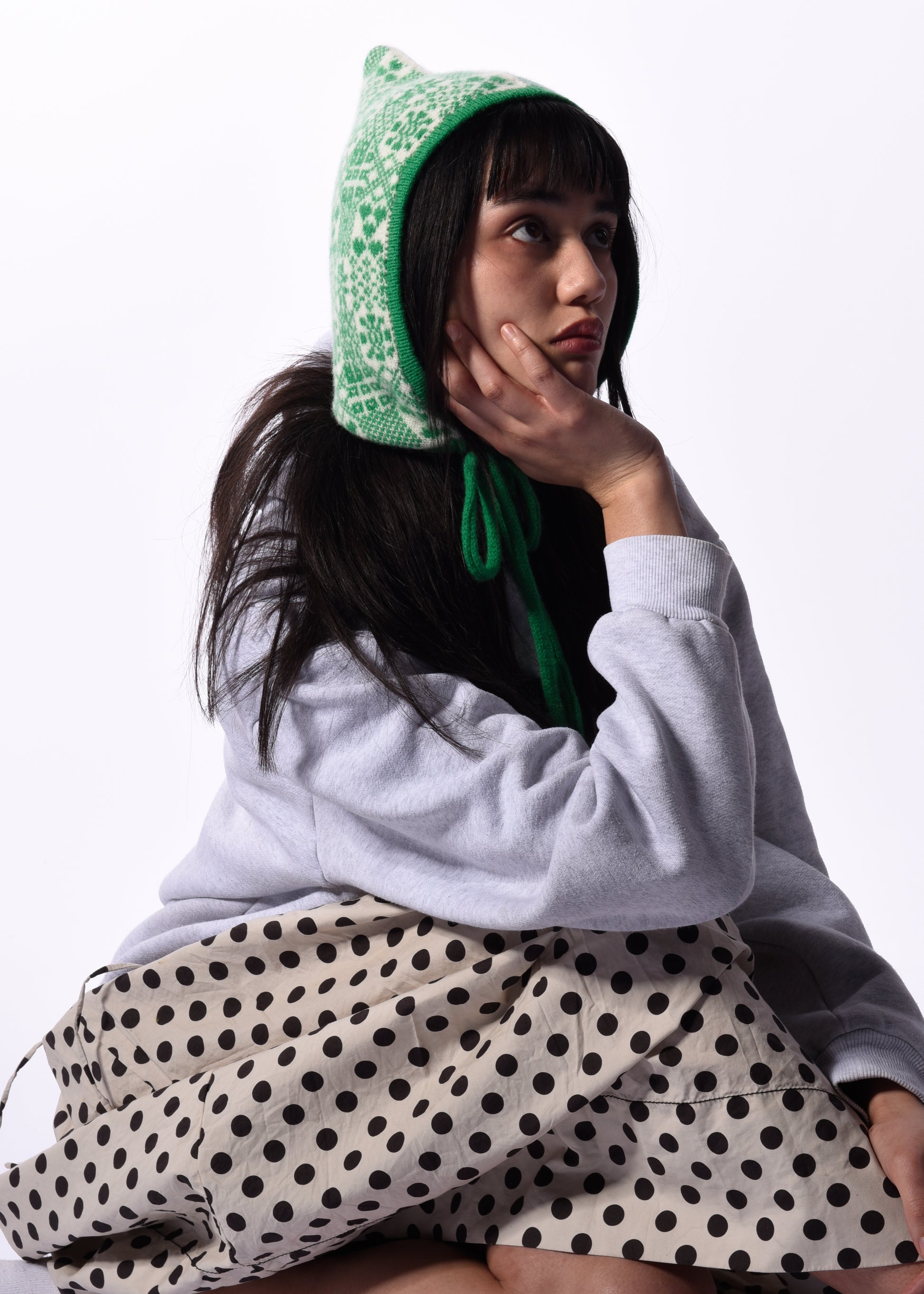 Person wearing a green bonnet with a white background
