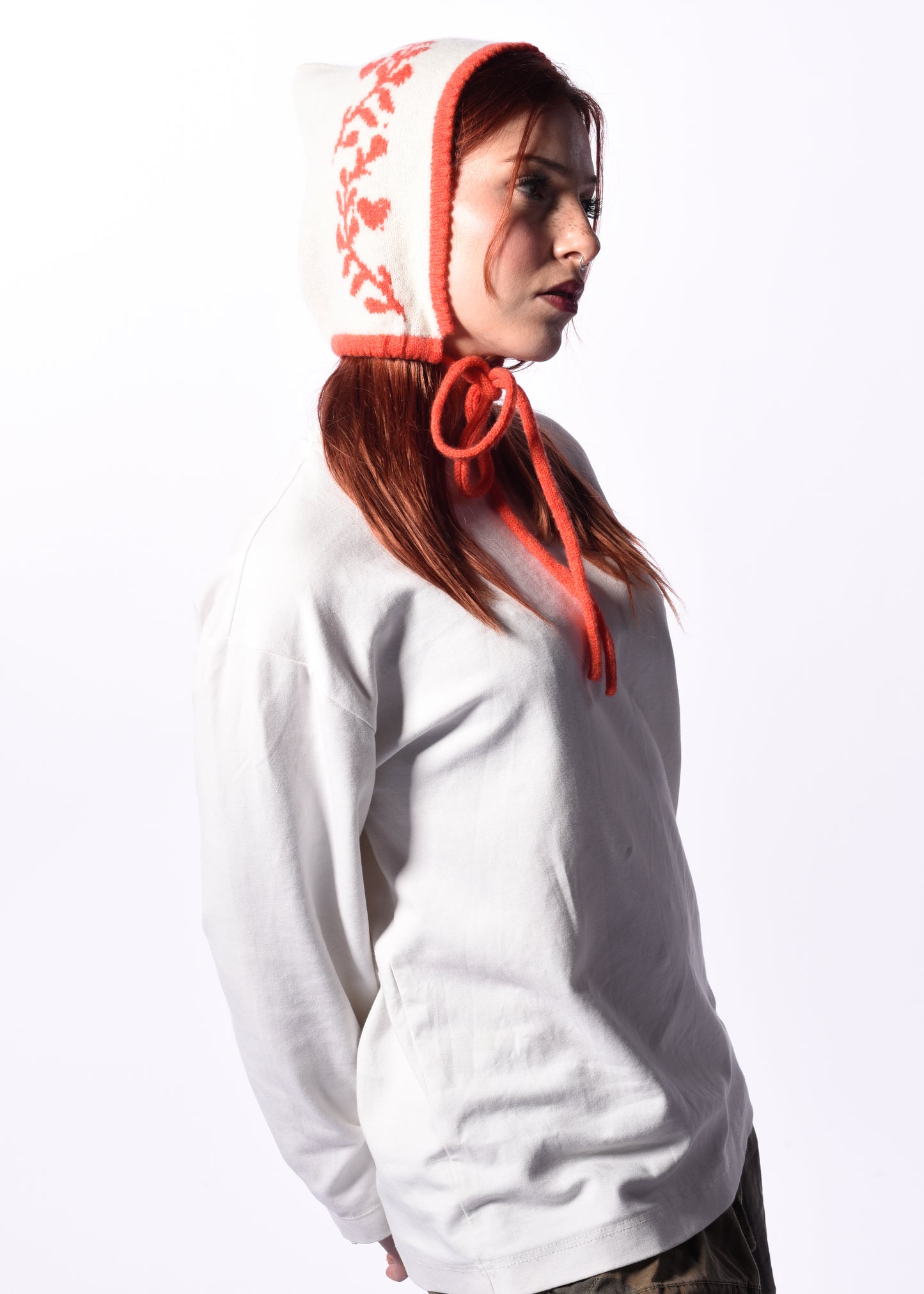 Person wearing a white hoodie with an orange hood against a white background