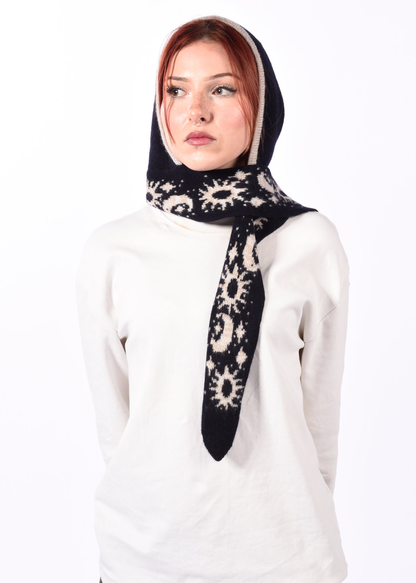 Woman wearing a navy and white patterned scarf bonnet on a white background