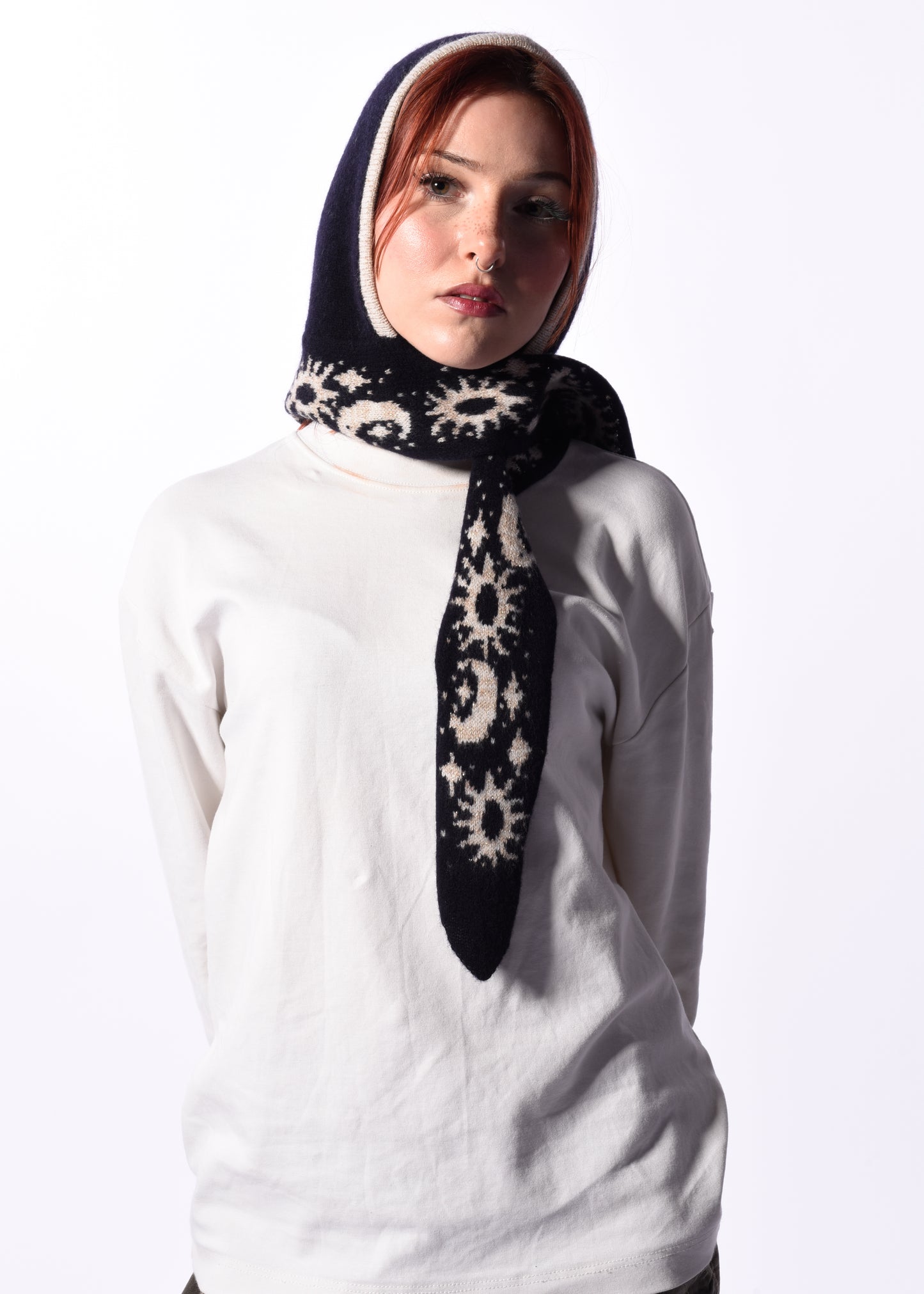 Woman wearing a black and white patterned scarf bonnet on a white background