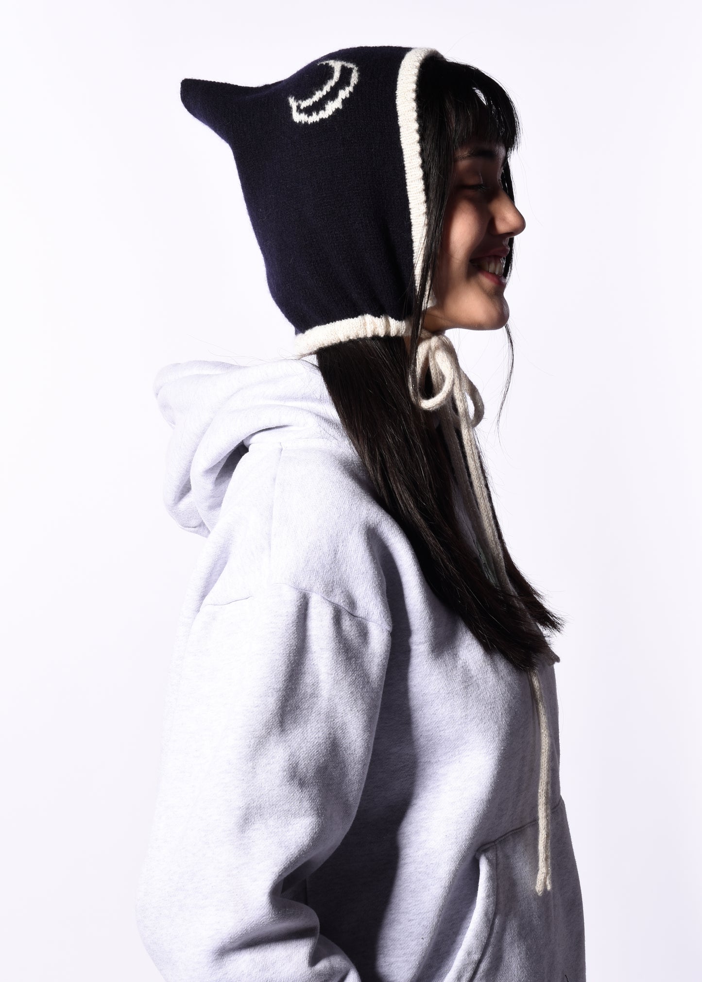 Person wearing a dark blue hood with white trim on a white background