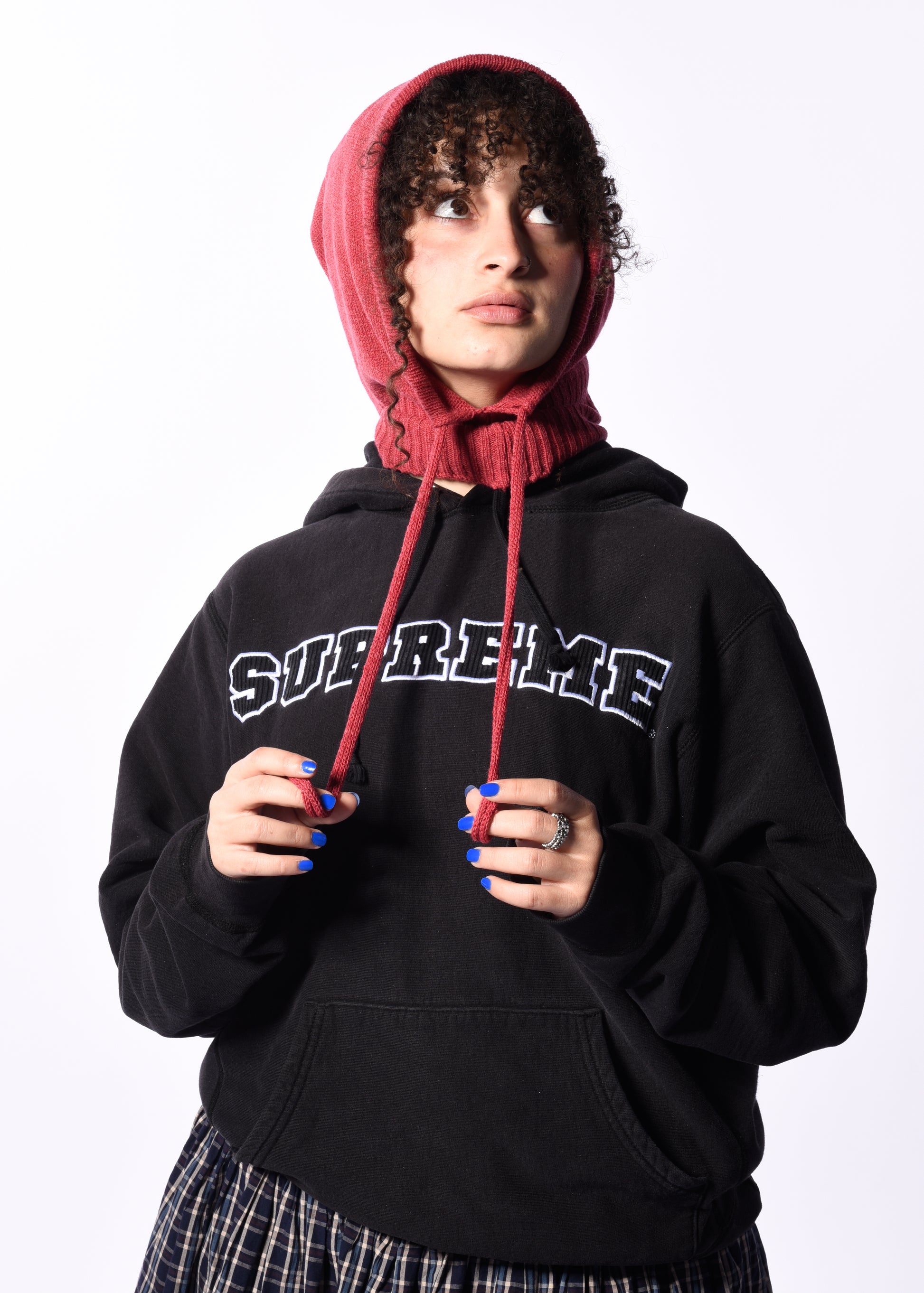 Person wearing a black hoodie with pink drawstrings on a white background