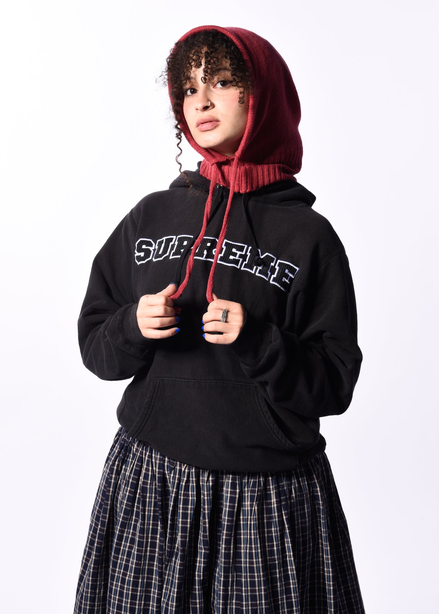 a woman wearing a dark pink balaclava in front of a white background