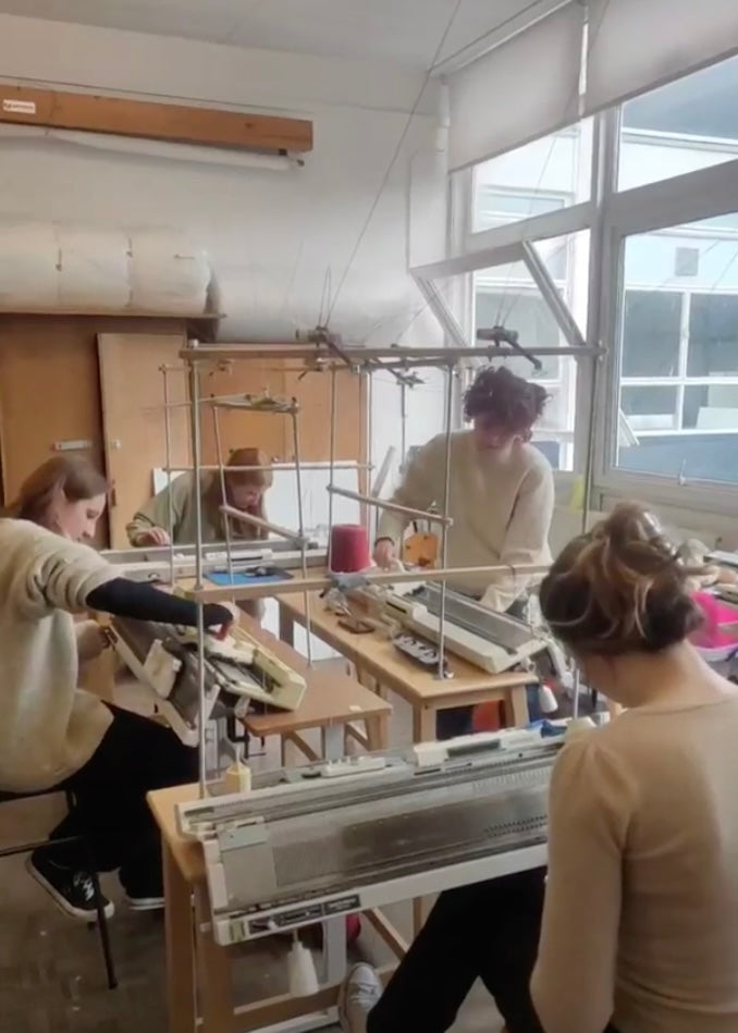 People working with textile equipment in a workshop setting