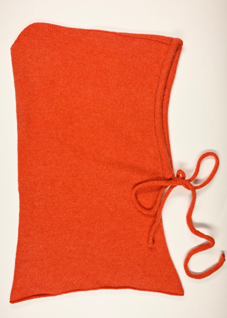 A flat lay of our cashmere knitted balaclava hood in orange with a white background 